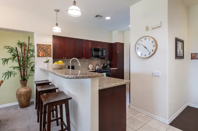 a kitchen with stainless steel appliances granite countertop a sink a stove and a refrigerator