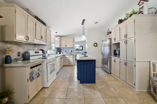 a kitchen with stainless steel appliances granite countertop a refrigerator sink and cabinets