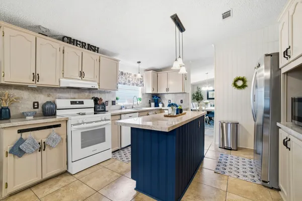 a kitchen with kitchen island granite countertop a sink appliances cabinets and counter space