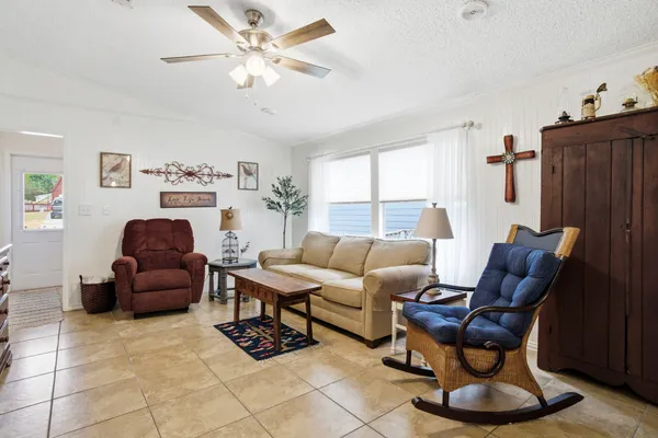 a living room with furniture a ceiling fan and a window