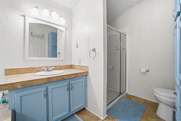 a bathroom with a sink a toilet a mirror and shower