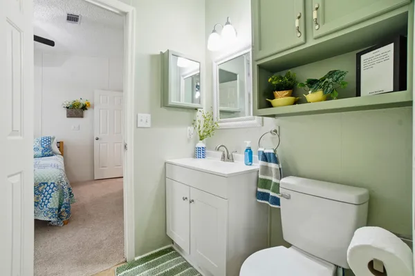 a bathroom with a toilet sink and mirror
