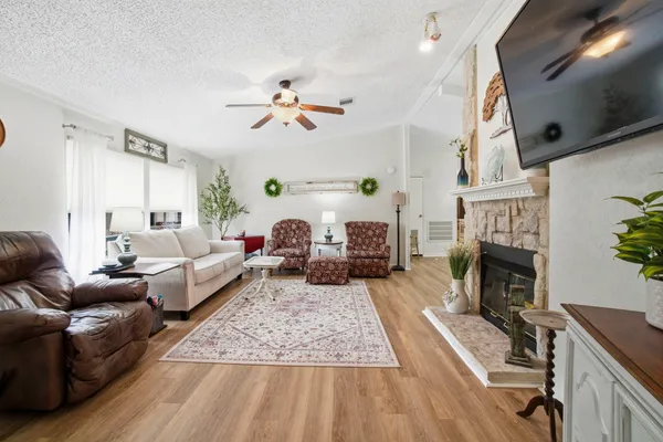 a living room with furniture a fireplace and a flat screen tv
