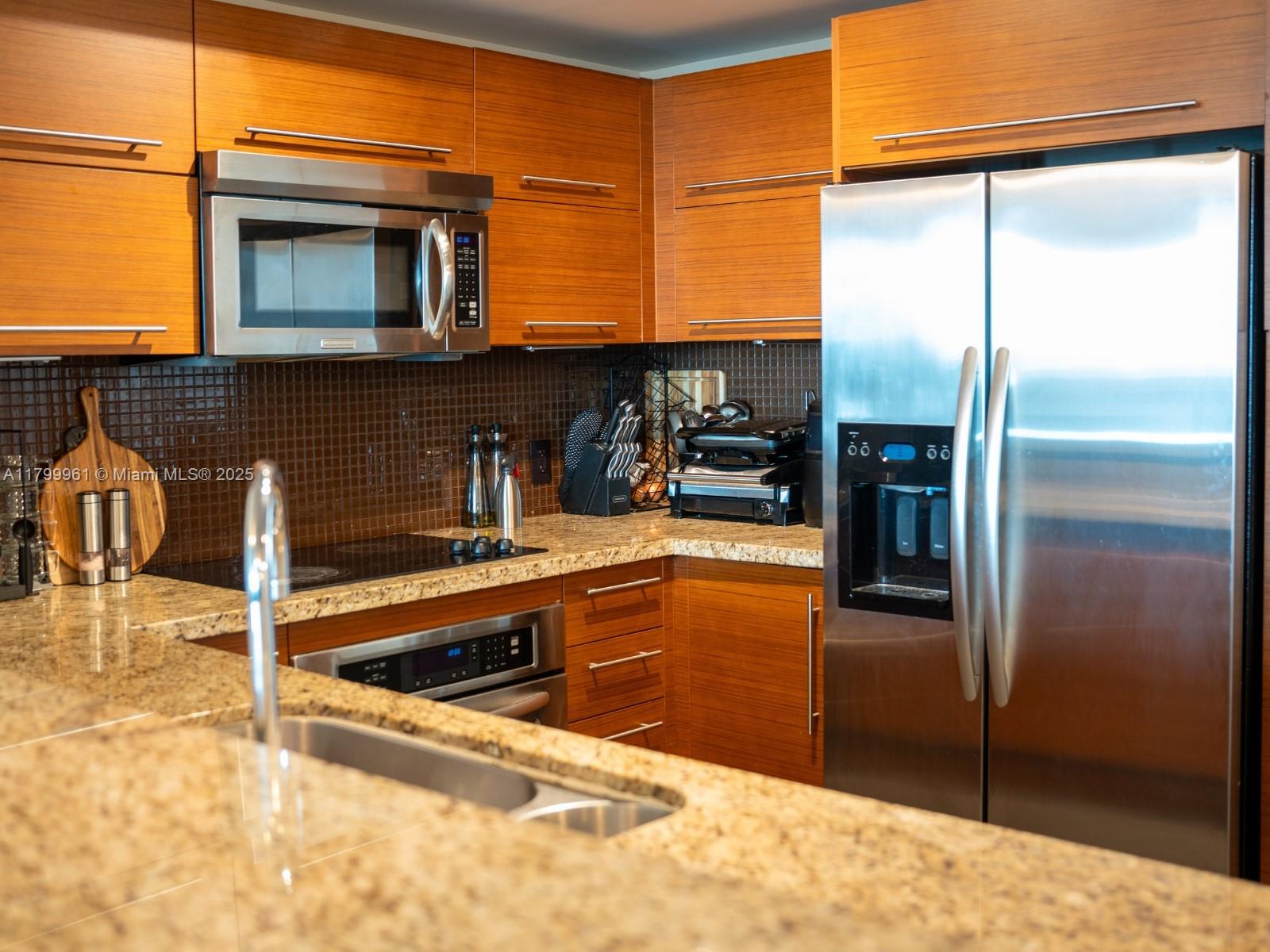 2681 North Flamingo Road, Unit 1206S Sunrise, FL 33323 - Photo 11 of 27 a kitchen with stainless steel appliances granite countertop a refrigerator and a sink