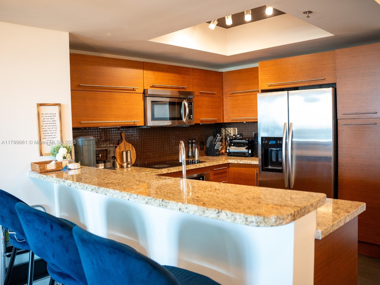 2681 North Flamingo Road, Unit 1206S Sunrise, FL 33323 - Photo 12 of 27 a kitchen with stainless steel appliances granite countertop a sink and a refrigerator