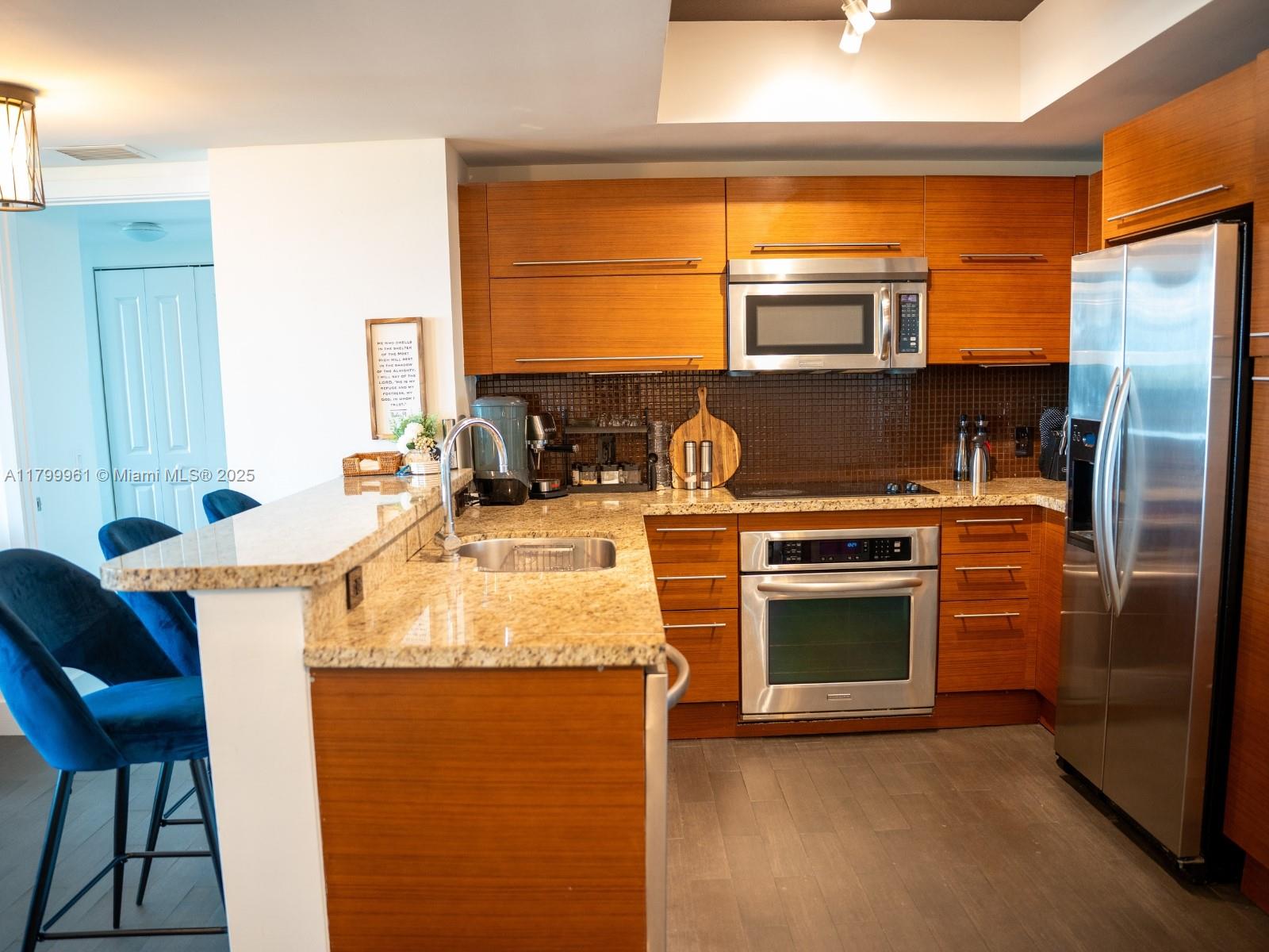 2681 North Flamingo Road, Unit 1206S Sunrise, FL 33323 - Photo 13 of 27 a kitchen with stainless steel appliances granite countertop a stove a sink and a refrigerator