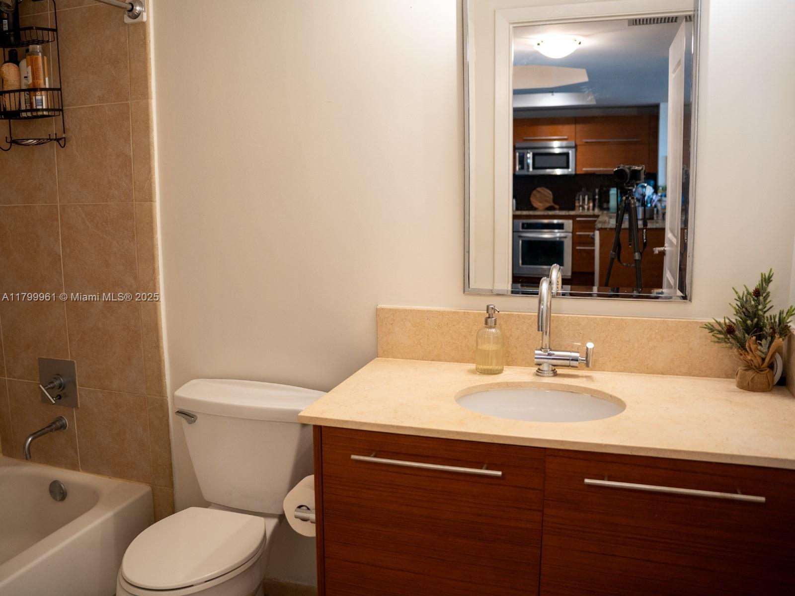 2681 North Flamingo Road, Unit 1206S Sunrise, FL 33323 - Photo 18 of 27 a bathroom with a sink toilet and mirror
