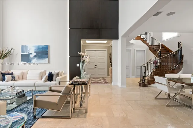 a living room with couches and kitchen view with wooden floor