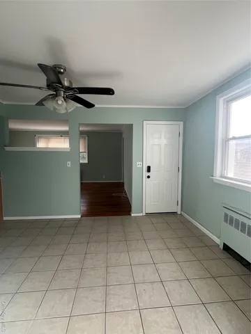 an empty room with windows and fan