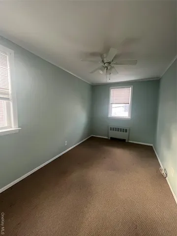 an empty room with a window and a ceiling fan