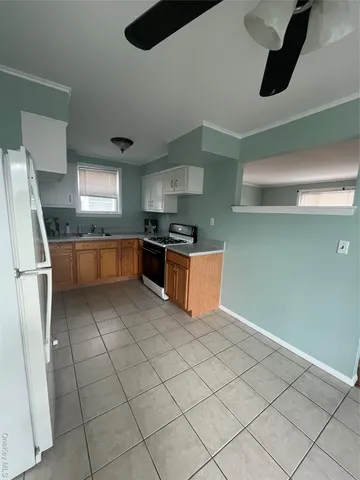 a kitchen with granite countertop a sink a stove top oven and refrigerator
