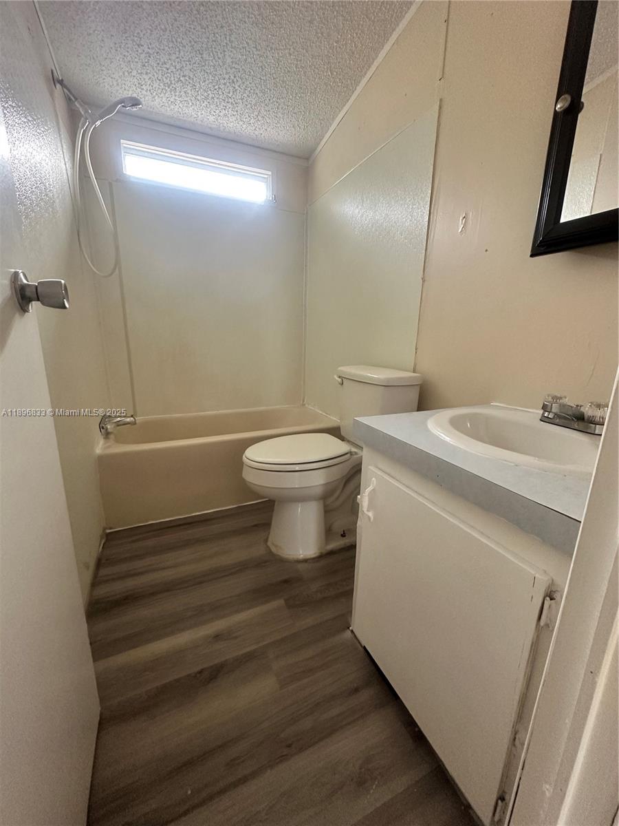22844 Tradewind Road, Unit H Boca Raton, FL 33428 - Photo 12 of 16 a bathroom with a sink a toilet and a mirror