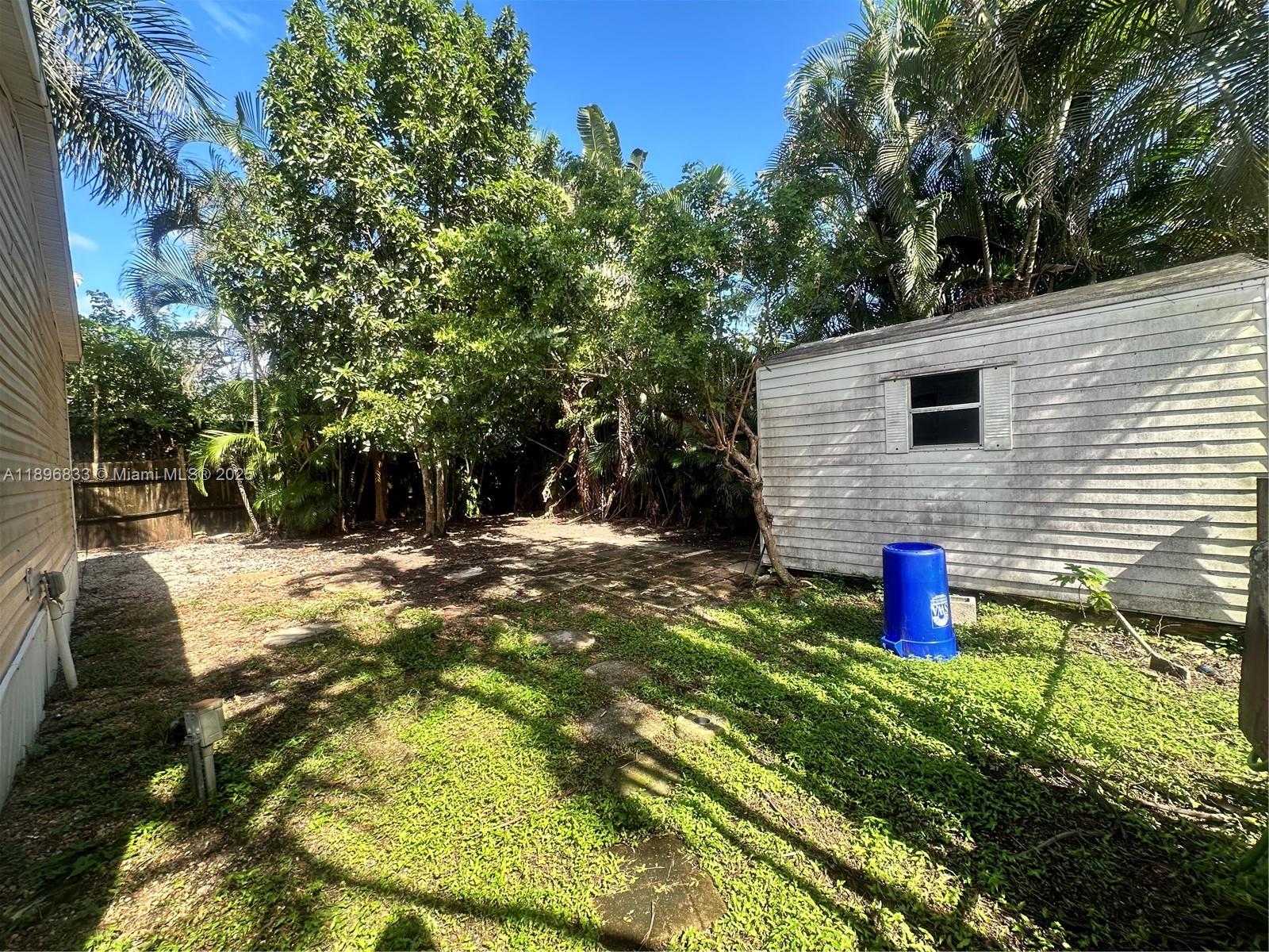 22844 Tradewind Road, Unit H Boca Raton, FL 33428 - Photo 14 of 16 a backyard of a house with table and chairs
