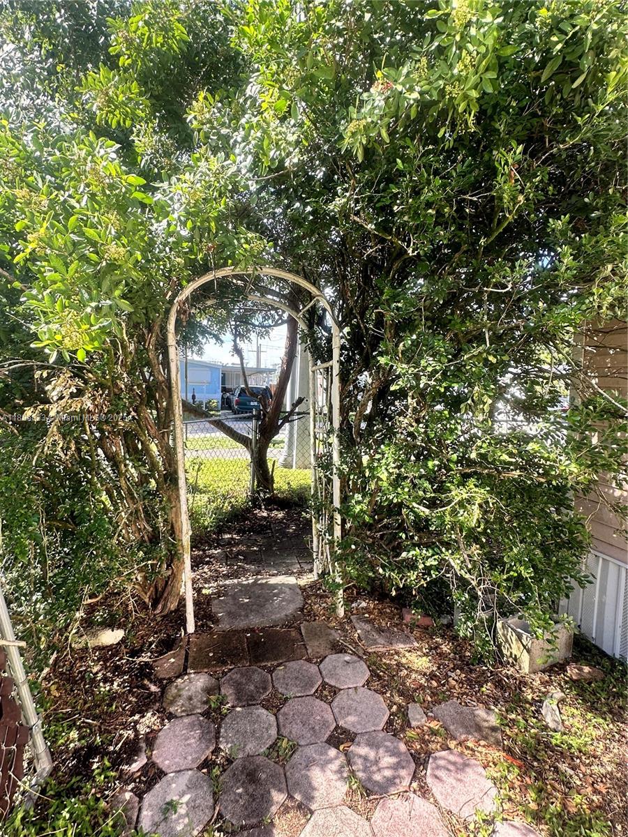 22844 Tradewind Road, Unit H Boca Raton, FL 33428 - Photo 16 of 16 a backyard of a house with table and chairs