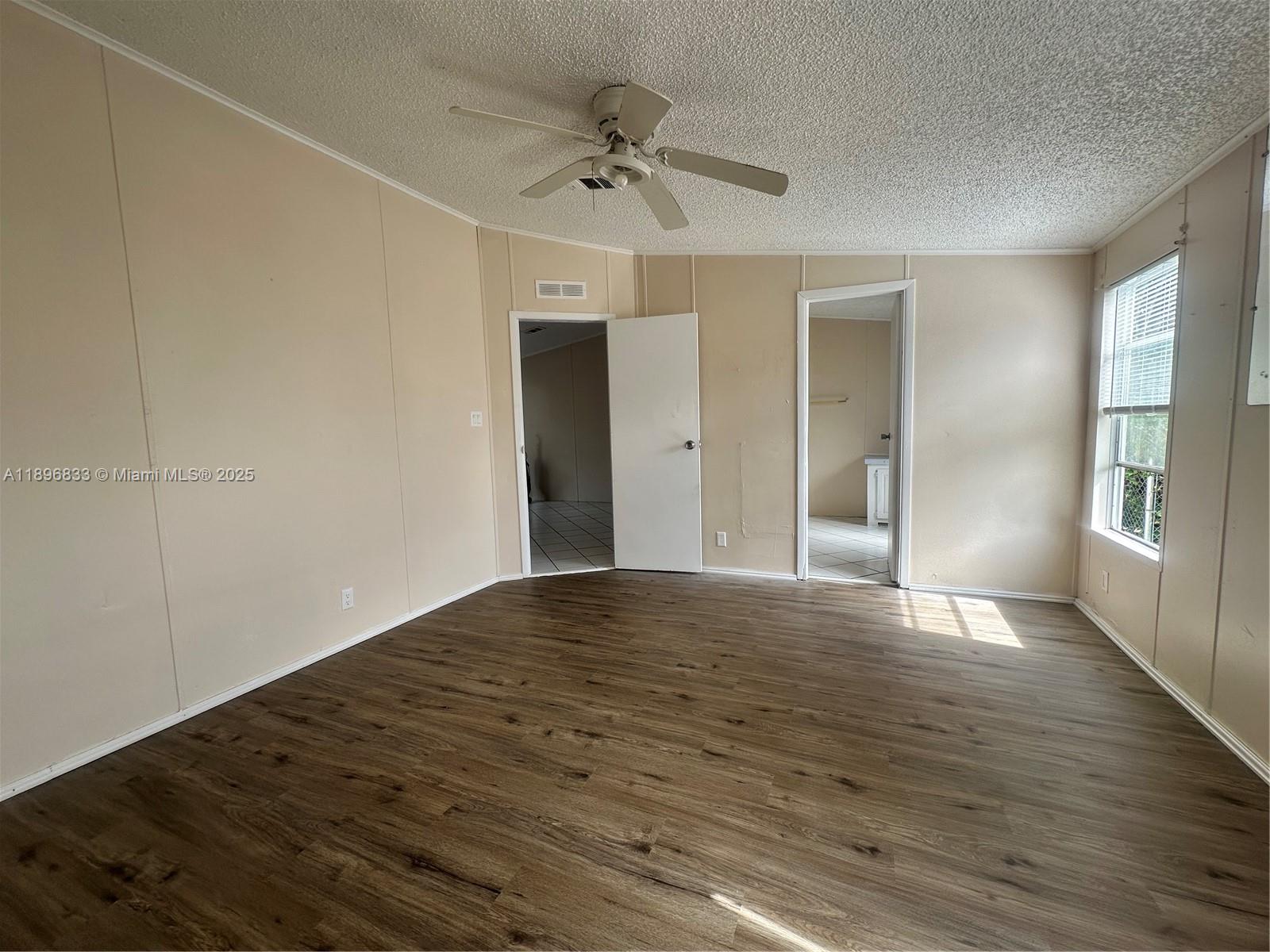 22844 Tradewind Road, Unit H Boca Raton, FL 33428 - Photo 4 of 16 a view of a livingroom with wooden floor and a ceiling fan