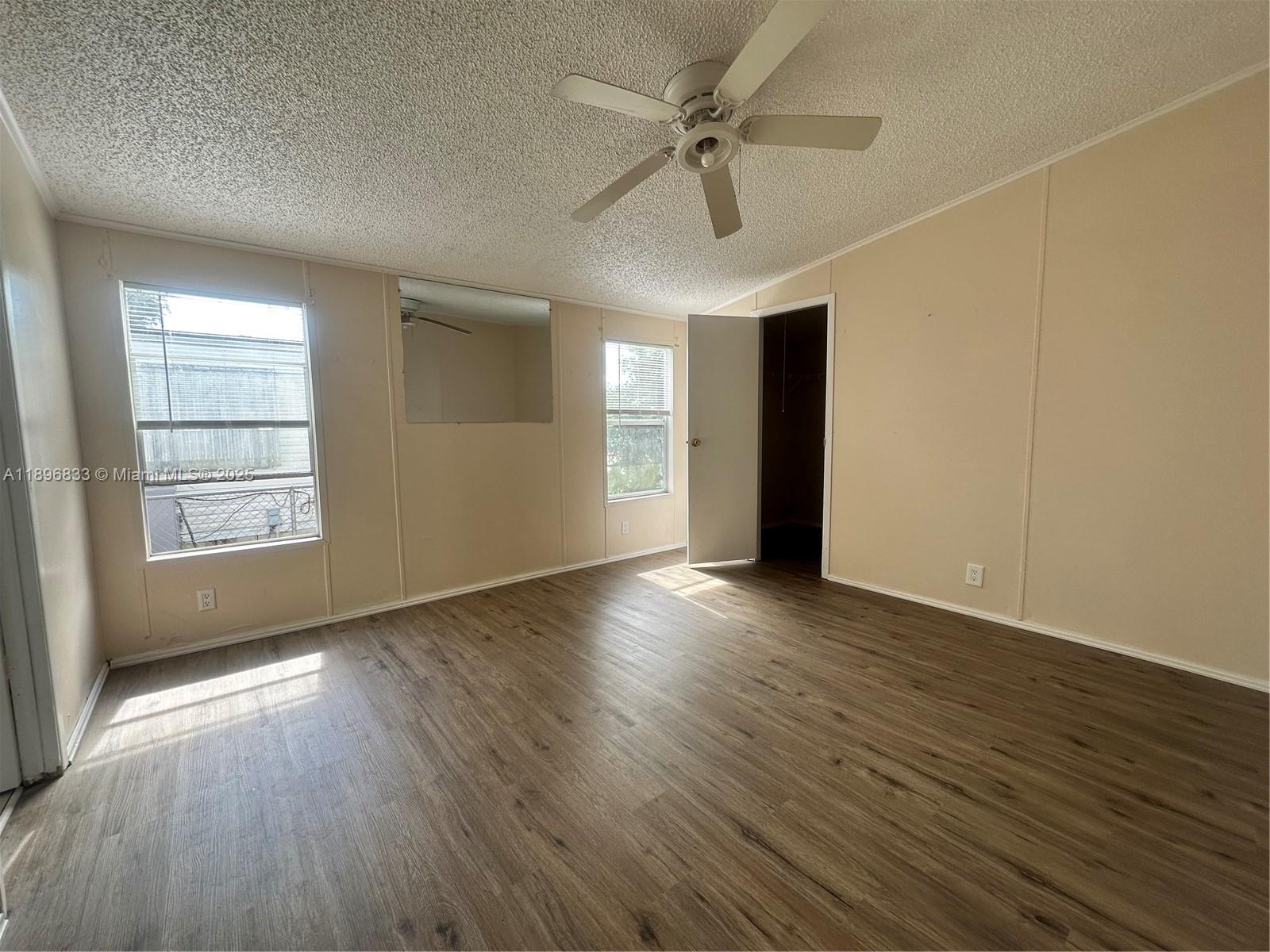 22844 Tradewind Road, Unit H Boca Raton, FL 33428 - Photo 5 of 16 an empty room with wooden floor and windows
