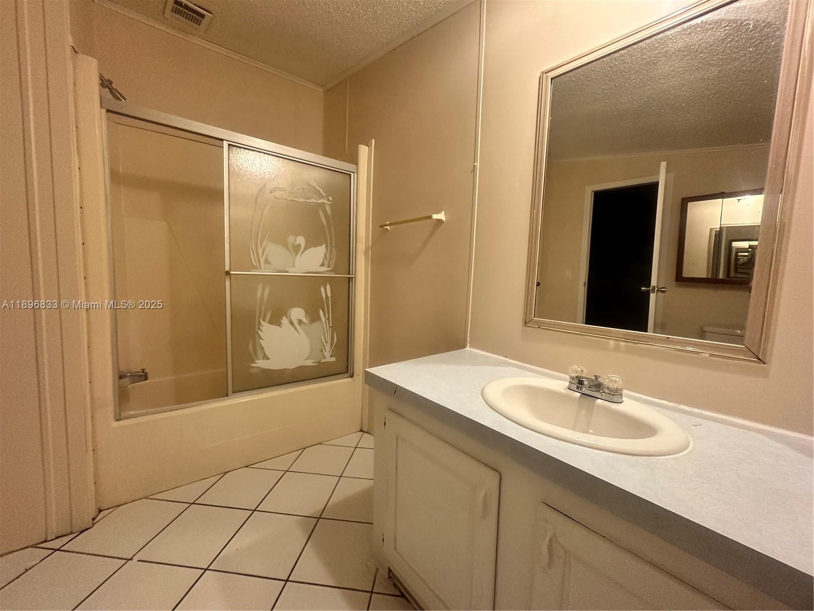 22844 Tradewind Road, Unit H Boca Raton, FL 33428 - Photo 7 of 16 a bathroom with a sink a shower and a mirror