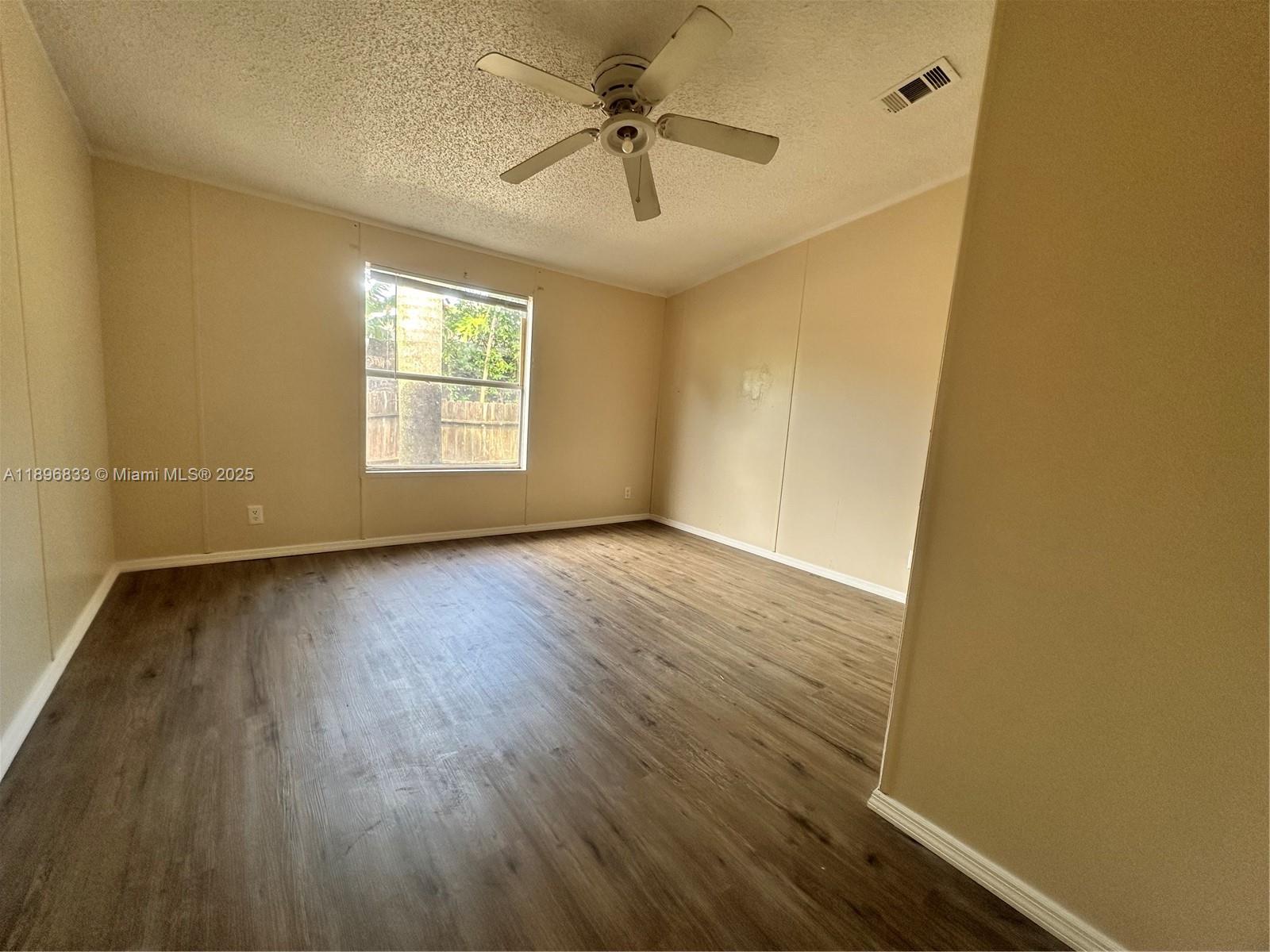 22844 Tradewind Road, Unit H Boca Raton, FL 33428 - Photo 9 of 16 wooden floor in an empty room with a window