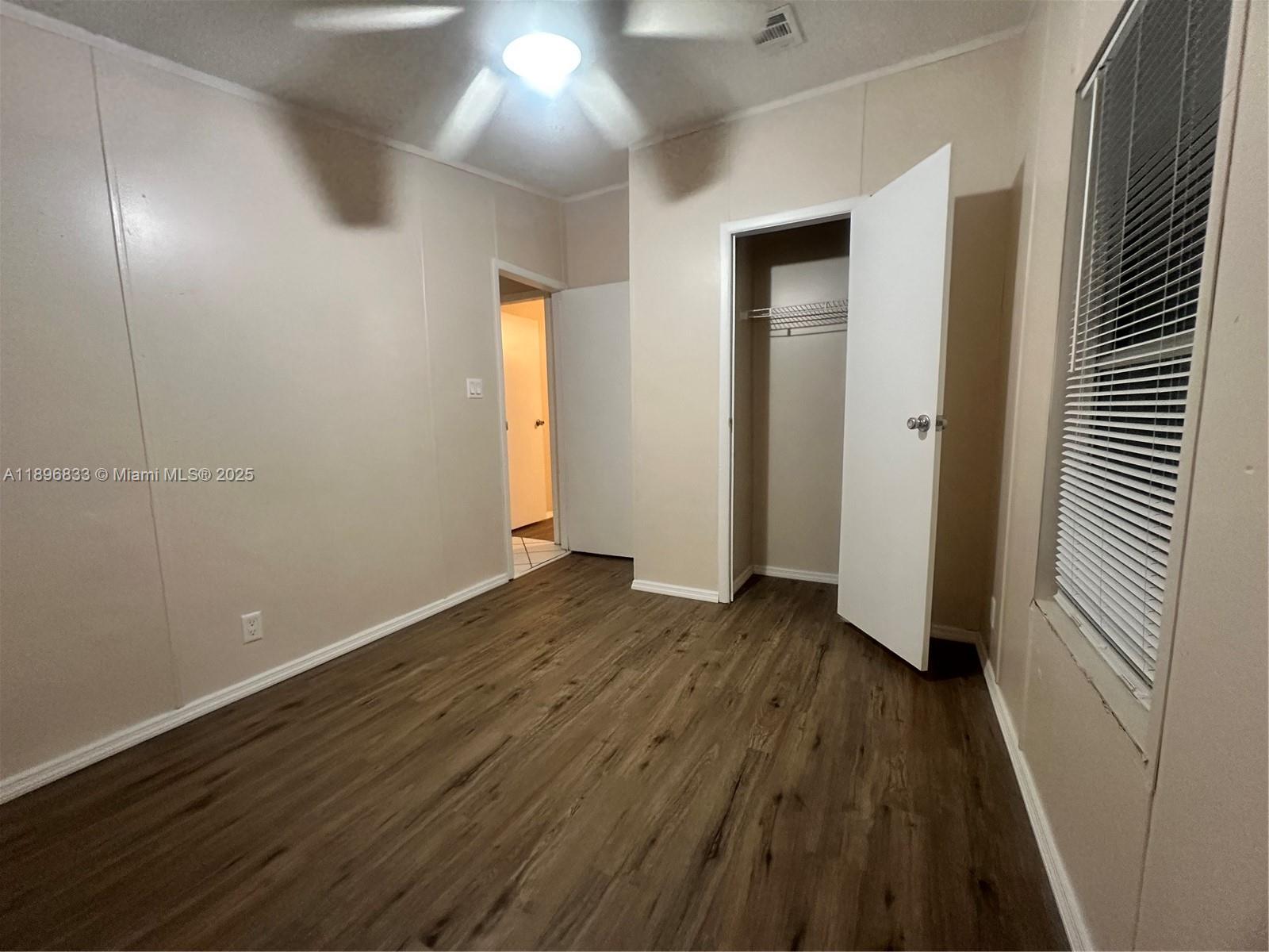 22844 Tradewind Road, Unit H Boca Raton, FL 33428 - Photo 10 of 16 an empty room with wooden floor and windows
