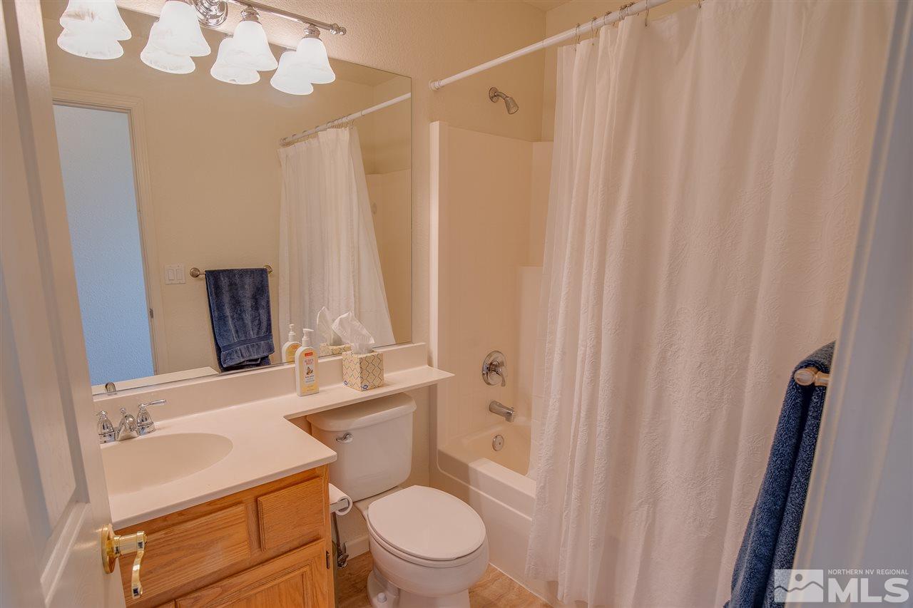1735 Legacy Village Road Reno, NV 89521 - Photo 13 of 23 a bathroom with a sink a toilet and shower curtain