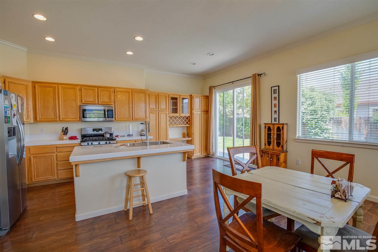 1735 Legacy Village Road Reno, NV 89521 - Photo 7 of 23 a kitchen with a table chairs microwave and cabinets