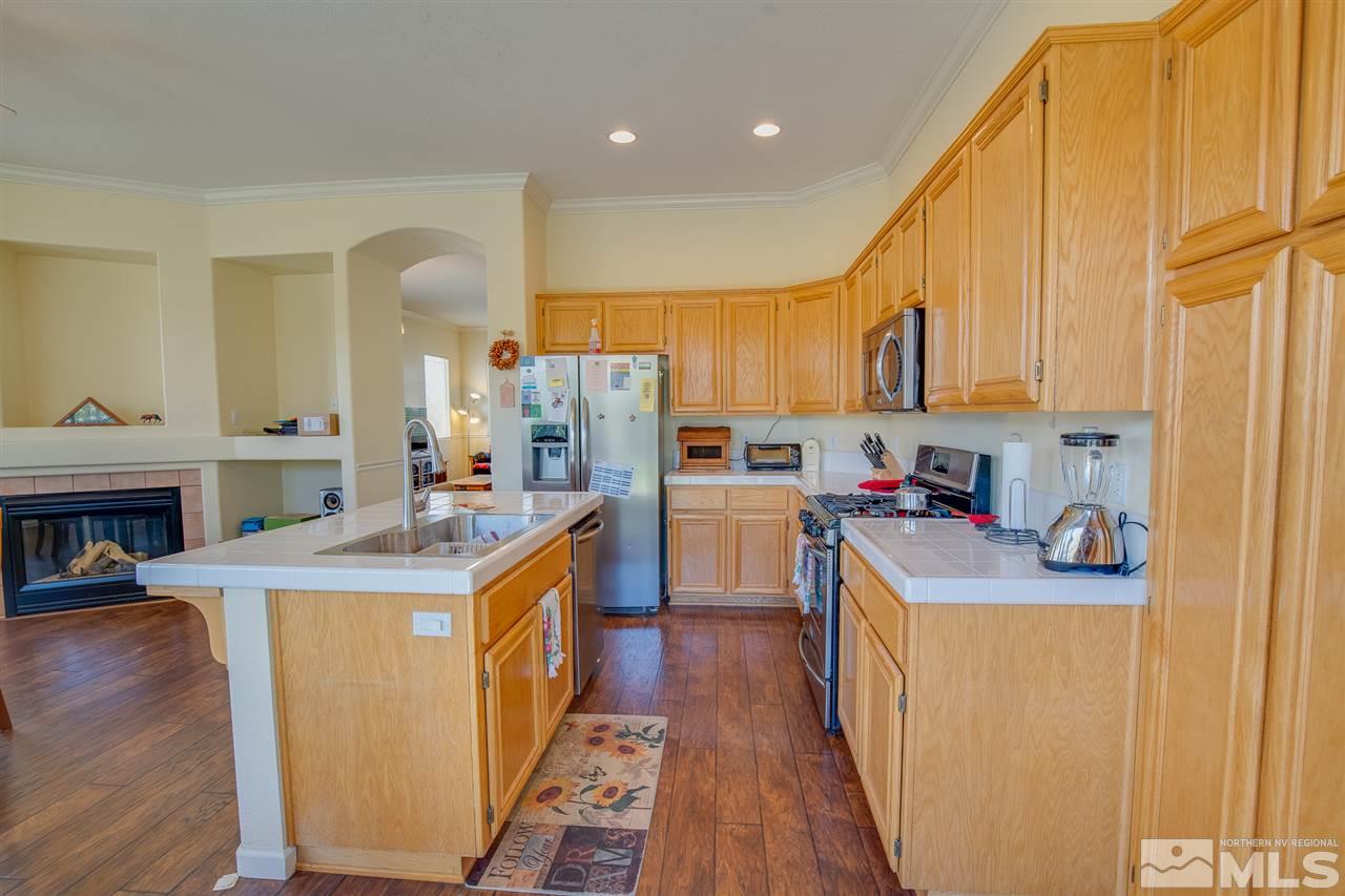 1735 Legacy Village Road Reno, NV 89521 - Photo 8 of 23 a kitchen with kitchen island a sink stove and refrigerator