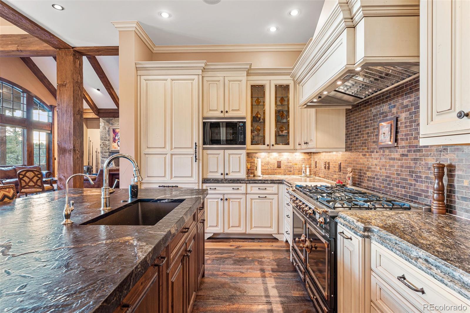 30 West Ranch Trail Morrison, CO 80465 - Photo 15 of 50 a kitchen with granite countertop a sink a counter space cabinets and stainless steel appliances