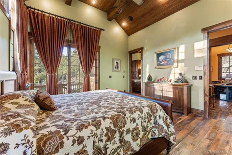 a bedroom with a bed dresser and a large window