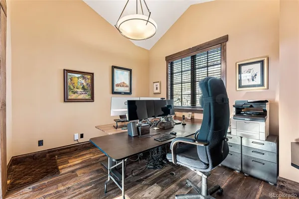 a view of a workspace with furniture and a window