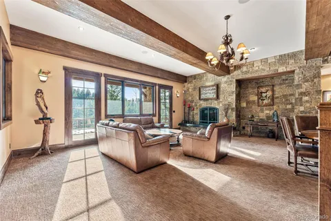 a living room with patio furniture and a chandelier