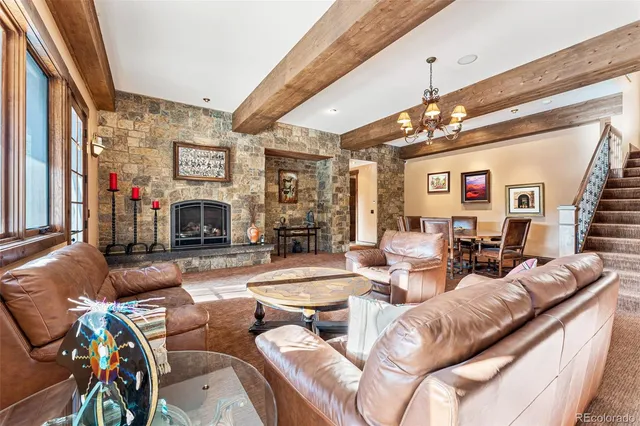 a living room with fireplace furniture and a chandelier