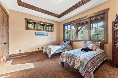 a bedroom with two beds and a large window