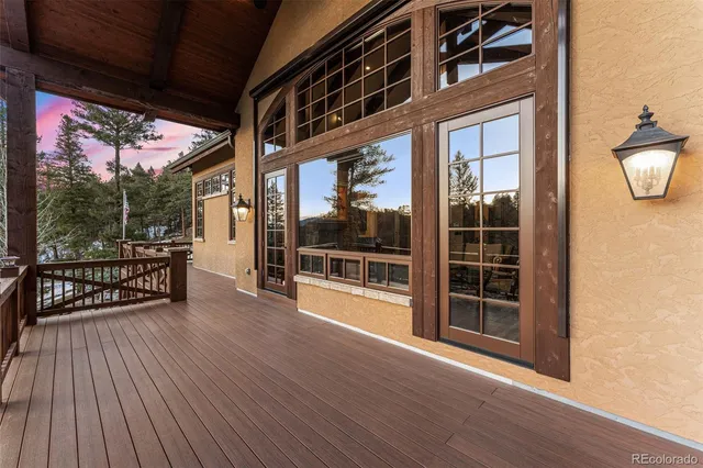 a view of a porch with wooden floor and floor to ceiling window