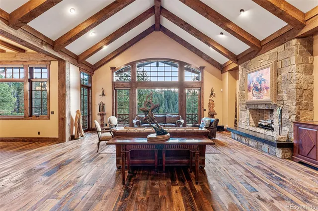 a living room with furniture a fireplace and floor to ceiling windows