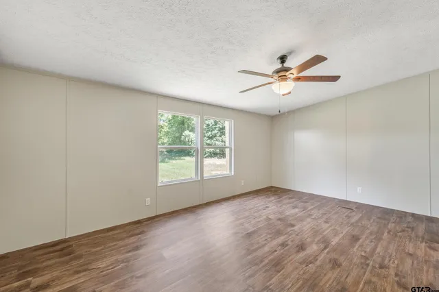 an empty room with a window and a fan