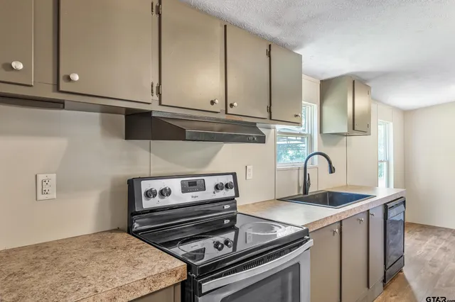a kitchen with granite countertop a stove and a sink
