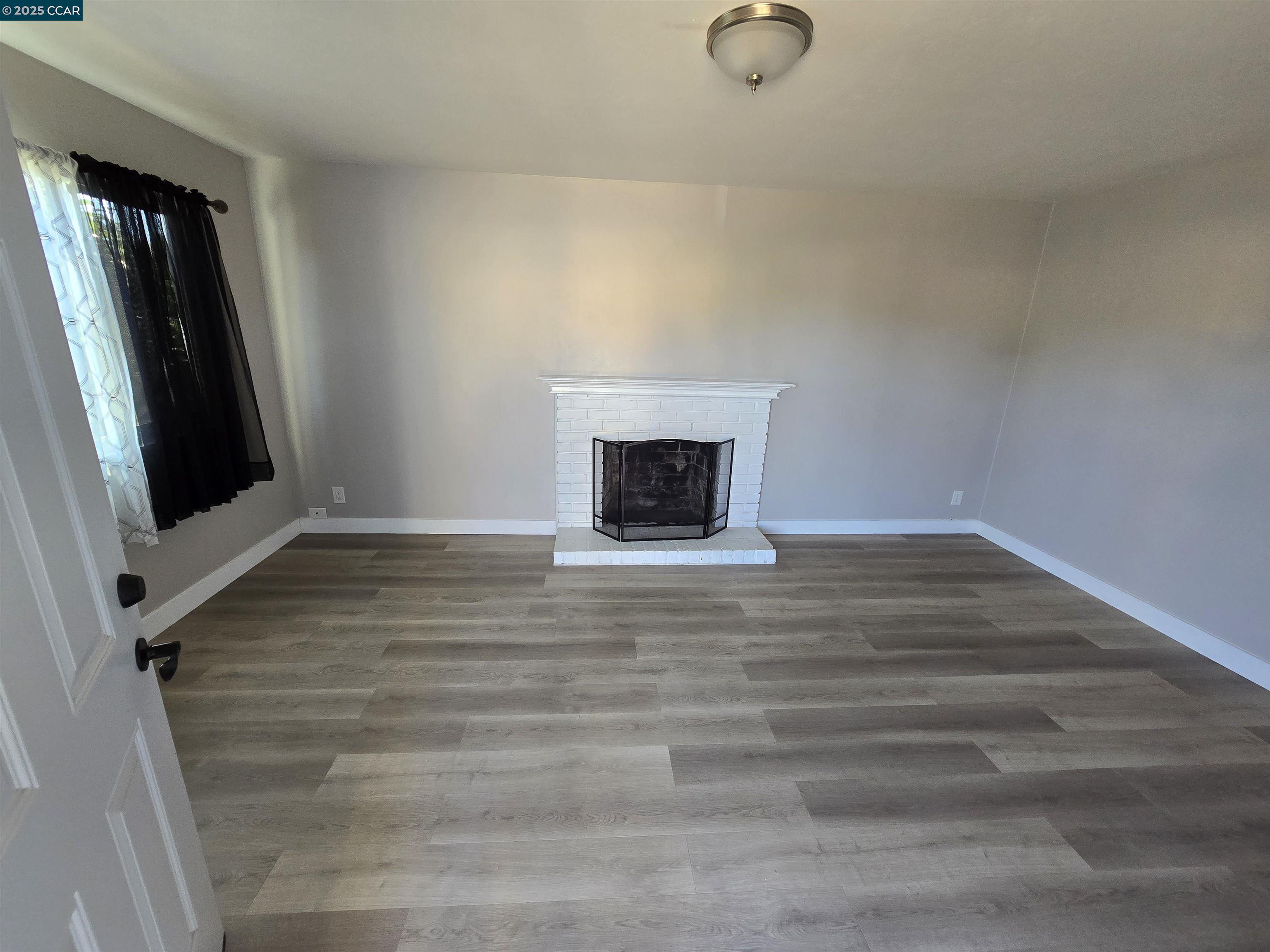 4370 Harmon Road El Sobrante, CA 94803 - Photo 2 of 10 a view of an empty room with wooden floor and a window
