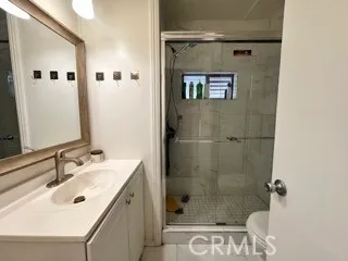 a bathroom with a shower sink and mirror