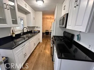 a kitchen with granite countertop a sink a stove and cabinets
