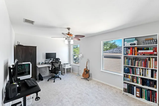 a view of a workspace with furniture and a book shelf