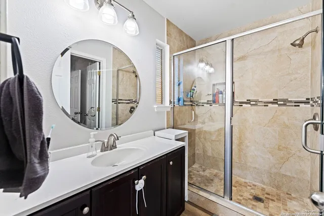 a bathroom with a double vanity sink mirror and shower