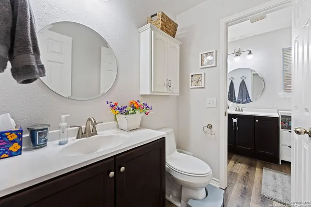 a bathroom with a sink vanity mirror and toilet