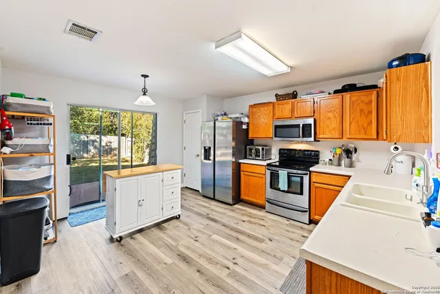 a kitchen with stainless steel appliances kitchen island granite countertop a stove a sink and a refrigerator