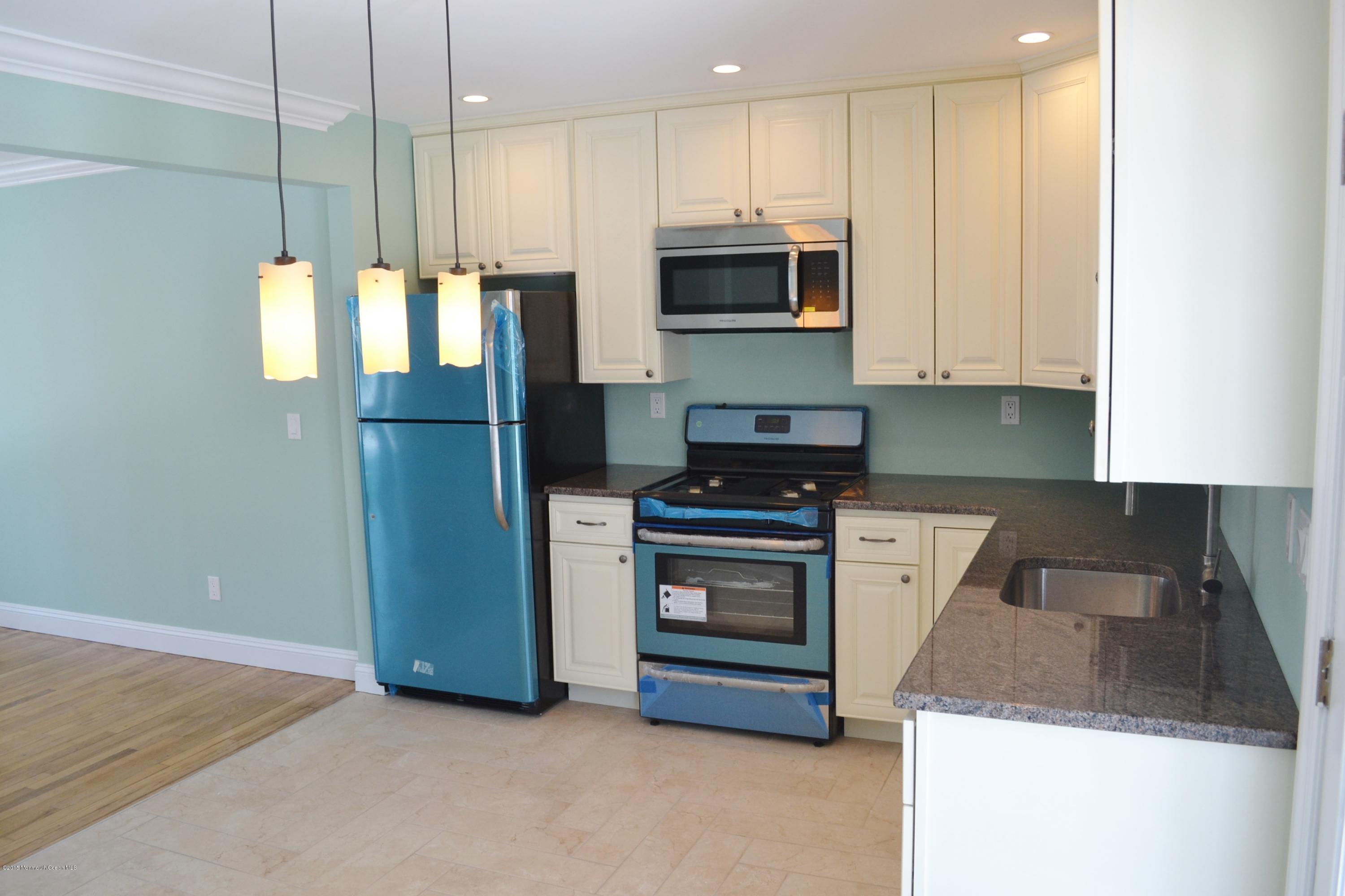 1000 Beaver Dam Road Point Pleasant, NJ 08742 - Photo 9 of 32 a kitchen with kitchen island granite countertop white cabinets and stainless steel appliances