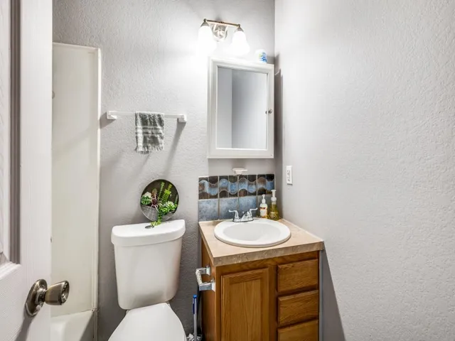 a bathroom with a sink mirror vanity and toilet