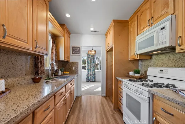 a kitchen with a sink a counter top space a large window and stainless steel appliances