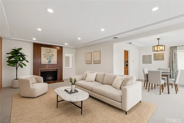 a living room with furniture a fireplace and a potted plant