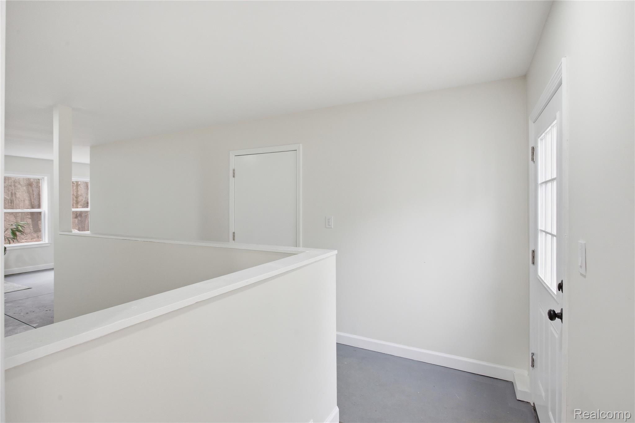 5350 List Road Grass Lake, MI 49240 - Photo 37 of 71 Hall featuring plenty of natural light, concrete flooring, and an upstairs landing