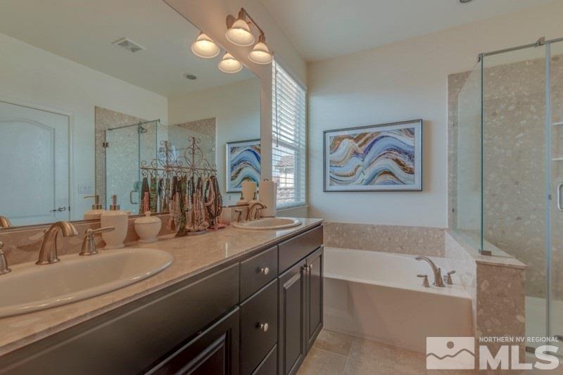 10602 Washington Reno, NV 89521 - Photo 19 of 25 a bathroom with a tub a sink and a large mirror