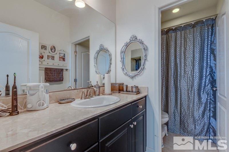 10602 Washington Reno, NV 89521 - Photo 22 of 25 a bathroom with a granite countertop sink and a mirror